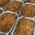 Gluten free and dairy free banana bread mini loaves cooling in foil pans, golden brown with a soft, moist texture