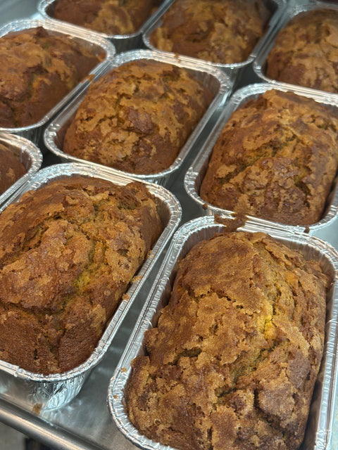 Gluten free and dairy free banana bread mini loaves cooling in foil pans, golden brown with a soft, moist texture
