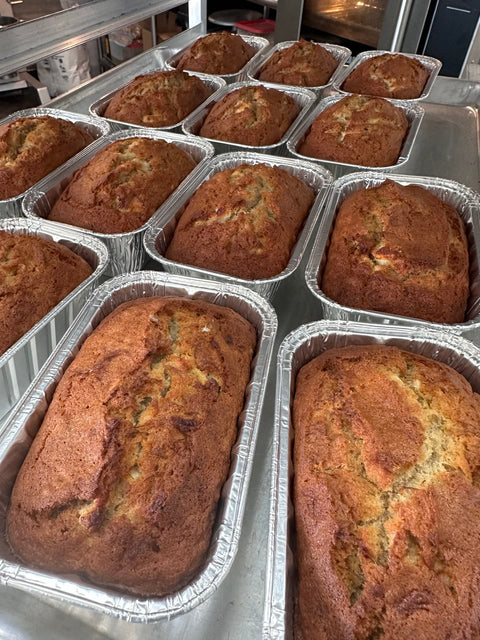 Gluten free and dairy free pumpkin bread mini loaves cooling in foil pans, golden brown with a soft, moist texture