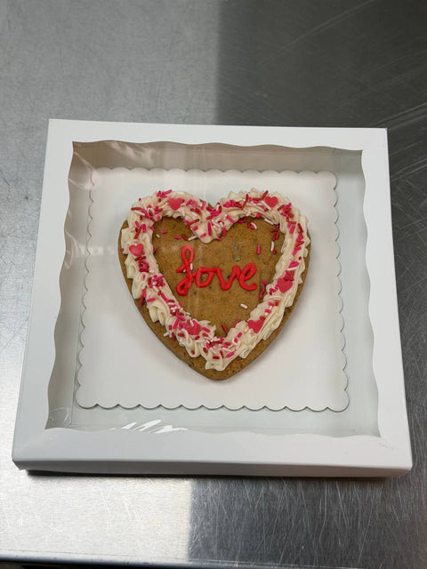 Heart-shaped Valentine’s cookie cake decorated with vanilla frosting, pink sprinkles, and “love” icing, gluten-free and dairy-free from Sinful Confections in Portland, Oregon